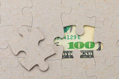 Kayıp yapboz parçası ve çerçevelenmiş Amerikan doları. Metin için kopyalama alanı olan arkaplan