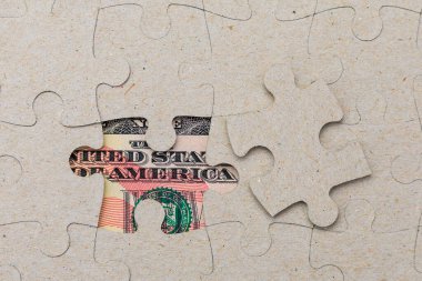 Kayıp yapboz parçası ve çerçevelenmiş Amerikan doları. Metin için kopyalama alanı olan arkaplan