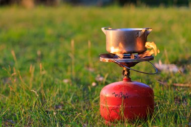 Pot on a gas burner in field conditions. Background with copy space for text