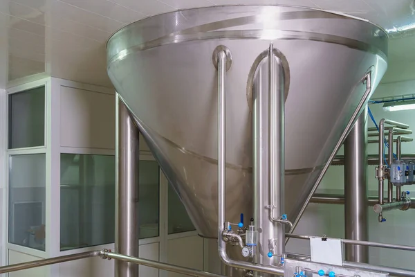 A stainless steel vat in the food industry at a brewery in the process of brewing beer. Background with selective focus and copy space for text