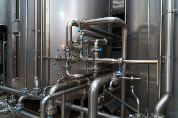 A stainless steel pipe system in the food industry at a brewery in the process of brewing beer. Background with selective focus and copy space for text