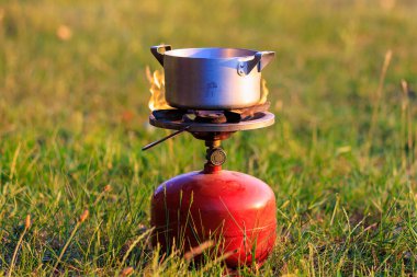 Pot on a gas burner in field conditions. Background with copy space for text