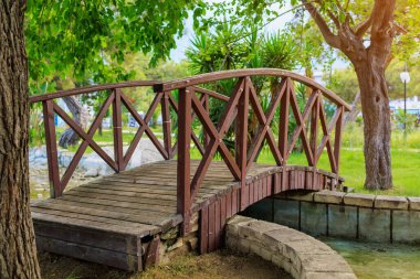 Wooden decorative bridge in a Turkish public park with haze at sunset. Background with copy space