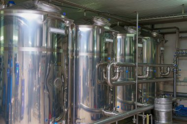 A stainless steel vat in the food industry at a brewery in the process of brewing beer. Background with selective focus and copy space for text