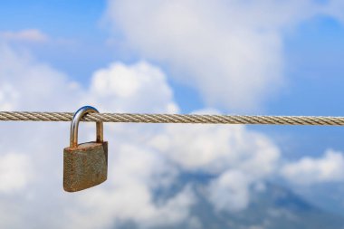 Çelik bir iple asma kilit, seçici odaklanma. Metin için kopyalama alanı olan arkaplan