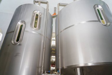 A stainless steel vat in the food industry at a brewery in the process of brewing beer. Background with selective focus and copy space for text
