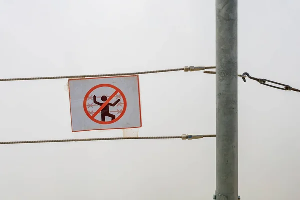 Warning signs about danger against the background of fog mountain cliffs, selective focus. Background with copy space for text