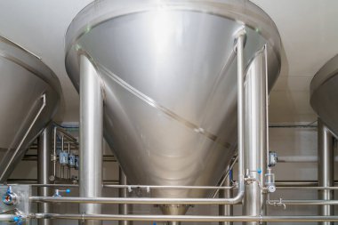A stainless steel vat in the food industry at a brewery in the process of brewing beer. Background with selective focus and copy space for text