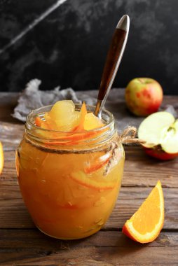 Şeffaf cam kavanozda elma reçeli. Hafif arka planda elma ve portakaldan reçel. Lezzetli marmelat..