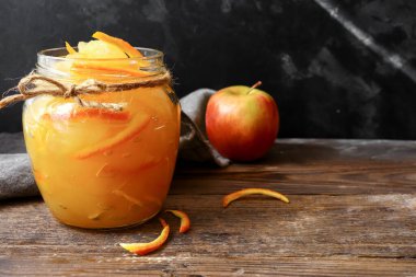 Şeffaf cam kavanozda elma reçeli. Hafif arka planda elma ve portakaldan reçel. Lezzetli marmelat..
