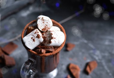 Sıcak çikolata ve lokum. Bardakta kakao, bardak. Karanlık arka plan. Boşluğu kopyala.