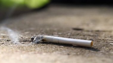 Cigarette on a concrete background. Smoke from a cigarette.