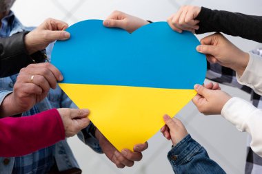 Ukrayna bayrağı renginde büyük bir kalbi tutan bir sürü insan. Ukrayna 'ya özgürlük ve destek. Savaşı durdurun..