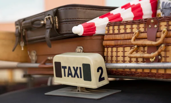 Close-up of the luggage rack of a taxi with several suitcases. Retro style, 70's and 80's. Concept of tourism and travelling on holidays.