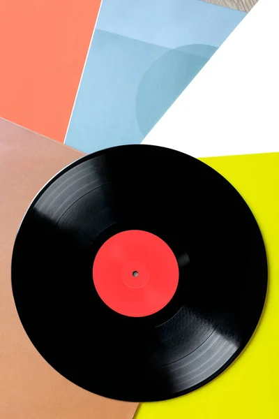 Composition of a vinyl record on colored covers. Top view. Space for text.
