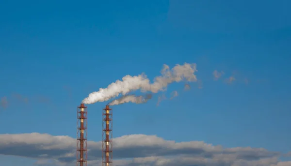 两条工业管道向大气中排放气态废物 蓝天背景下的白烟污染环境 — 图库照片