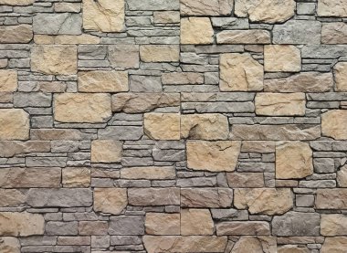 Gri ve kahverengi renkli eski bir taş duvar. Tuğla desenli taş duvar. Gri arkaplan.