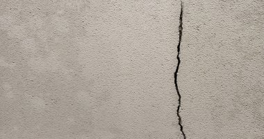 Gri beton duvarda bir çatlak. Sağda dikey çatlak.