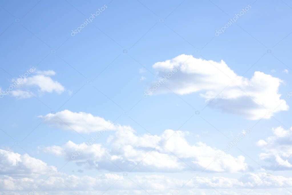 There are a lot of high fluffy clouds in the blue sky. Beautiful view of the blue sky. Heavenly, soothing background.