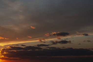 Kızıl güneş ufukta kayboldu ve yüksek bulutlar akşam gökyüzünü kapladı. Güzel gün batımı.