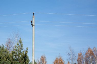 Açık, sonbahar gökyüzünün arka planında elektrik kabloları olan bir direk. Güç hatları ve iletişim.