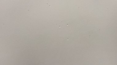 Hasarlı ve çukurlu gri pürüzsüz bir duvar. Çizikli hafif doku.