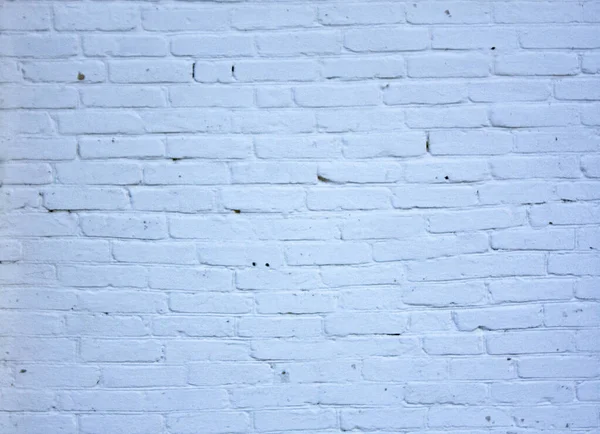 Eski, düzensiz, tuğla bir duvar. Tuğla rengi mavi..