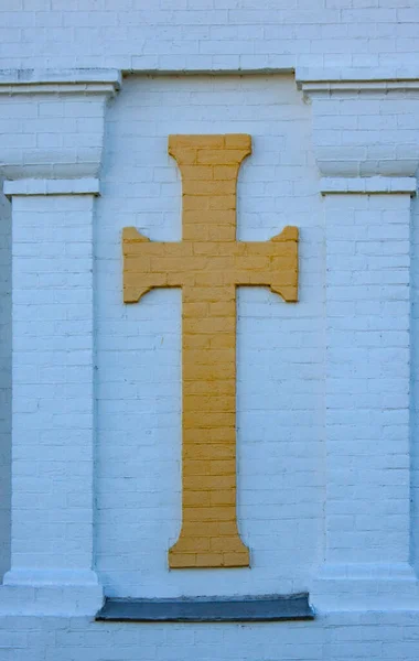 教堂的砖墙上有一个黄色的东正教十字架 带有宗教符号的砖块纹理 — 图库照片
