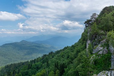 Yeşil ağaçlı muhteşem dağların manzarası. Güzel yerlerde seyahat etmek..