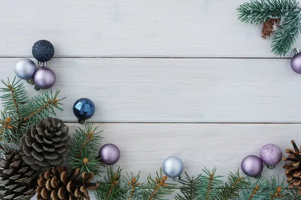 Yeşil köknar ağacı dalları ve konilerinin en üst görüntüsü, beyaz tahta arka planda noel topları, çokça kopyalanmış alan. Noel konsepti                                         