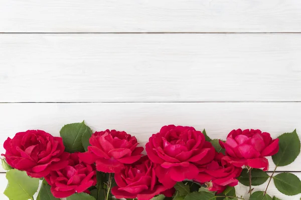 Beyaz ahşap arka planda kırmızı güllerin üst sıra görüntüsü, bir sürü kopyalanmış alan. Sevgililer Günü 'nde Greetimgs, Mutlu yıllar, yıldönümü