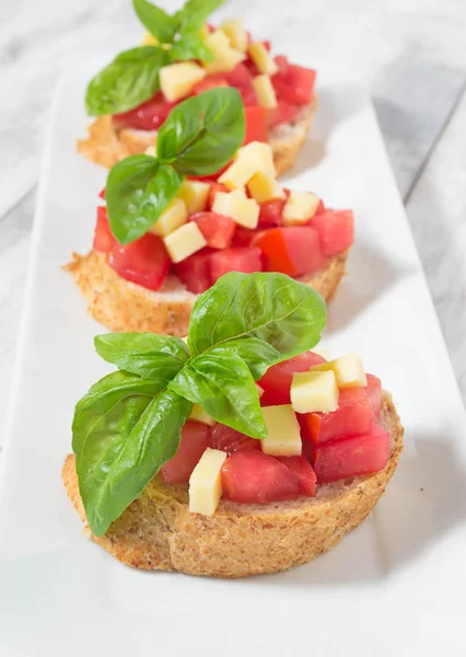 Bruschetta z pomidorem, serem i bazylią — Zdjęcie stockowe