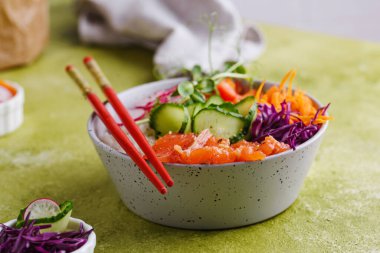 Somon, pirinç ve sebzeli Hawaii poke kasesi.