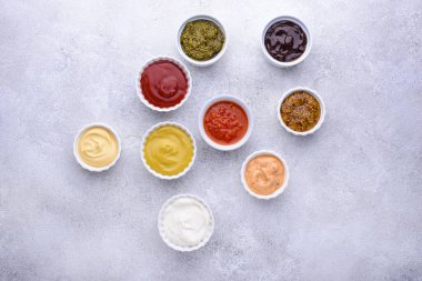 Farklı soslar seti. Ketçap, hardal, mayonez, pesto, marinara, adjika ve peynir sosu.