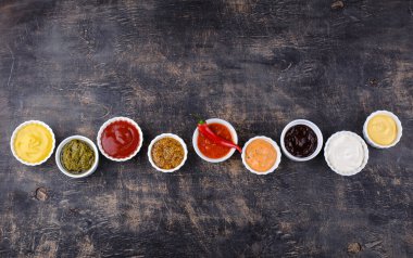 Farklı soslar seti. Ketçap, hardal, mayonez, pesto, marinara, adjika ve peynir sosu.