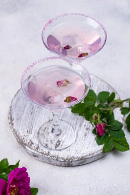 Gül şurubu ve çiçekli pembe martini kokteyli. Yaz içeceği