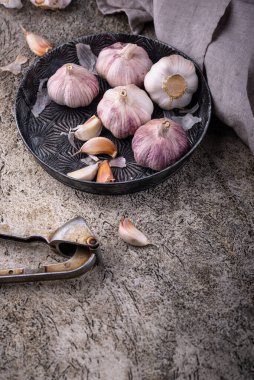 Taş masa arkasında taze organik sarımsak.