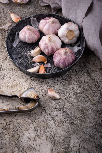 Taş masa arkasında taze organik sarımsak.