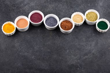 Çeşitli süper yiyecekler tozu. Acai, matcha, spirulina, zencefilli kurutulmuş yabanmersini ve zerdeçal.