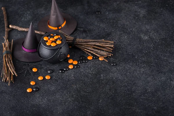 Halloween festive background with witches hat, cauldron and broom