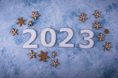 2023 Yeni Yıl ve Noel kompozisyonu ve mavi arka planda zencefilli kurabiyeler