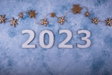 2023 Yeni Yıl ve Noel kompozisyonu ve mavi arka planda zencefilli kurabiyeler