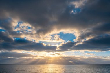 Gün batımında suyun üzerinde inanılmaz bulutlar.
