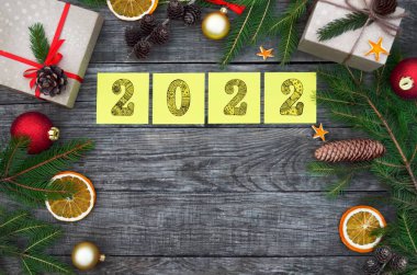 Sarı yapışkan notlar, üzerinde 2022 rakamları olan şenlikli ahşap arka plan..