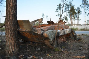 Dmytrivka village, Kyiv region, Ukraine - April 14, 2022: Destroyed infantry fighting vehicle with a white painting V of the Russian army following the Ukrainian forces counter-attacks. clipart