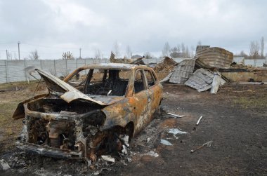 Myla köyü, Kyiv bölgesi, Ukrayna - Nisan 03, 2022: Bir tank bombardımanı sonucu araba ve özel bir ev Rus işgalciler tarafından tamamen yandı.