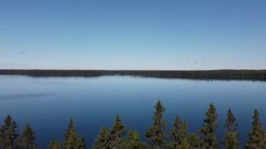 craning drone shot of trees and lake in Manitoba
