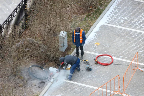 Siyah ceketli ve kırmızı eldivenli genç bir işçinin yüksek açılı fotoğrafı duvarda...