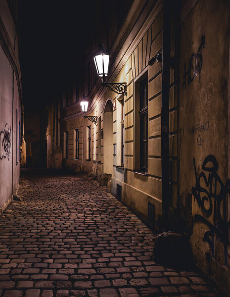 View of a dark and illuminated cobblestone street in the old town of prague at night 2021