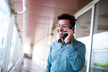 business, communication concept. Young Indian man talking on mobile phone. Happy customer
